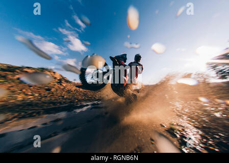 Motocross Fahrer fahren durch das Wasser, spritzen Stockfoto