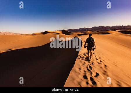 USA, Californien, Death Valley, Death Valley National Park, Mesquite flachen Sand Dünen, man walking auf Dune Stockfoto