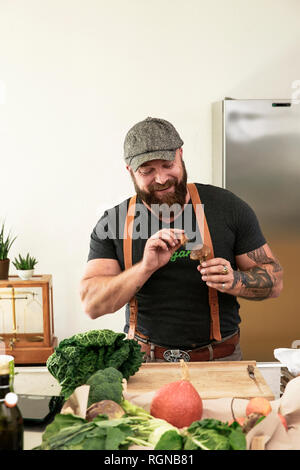 Vegan mann Reinigung Champignons in seiner Küche Stockfoto