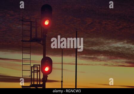 Orland Park, Illinois, USA. Ein rotes Signal Schutz ein Block von Eisenbahnschienen kurz nach Sonnenuntergang. Stockfoto