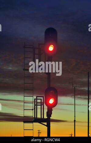 Orland Park, Illinois, USA. Ein rotes Signal Schutz ein Block von Eisenbahnschienen kurz nach Sonnenuntergang. Stockfoto