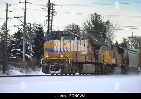 Geneva, Illinois, USA. Die Union Pacific Railroad Güterzug erregt etwas Schnee, wie es Köpfe westwärts durch Genf aus Chicago, Illinois. Stockfoto