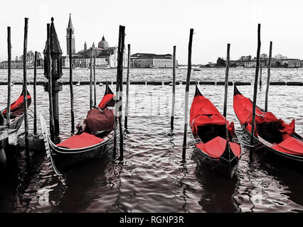 Red vintage Gondeln angedockt an der Pier, dem Piazza San Marco in Venedig, Italien. Farbe in Schwarz und Weiß Stockfoto