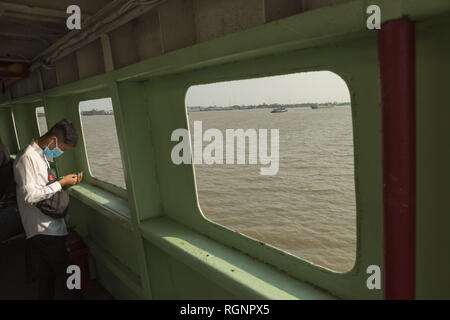 Junge Mann an der Fähre überqueren den Fluss Saigon Stockfoto