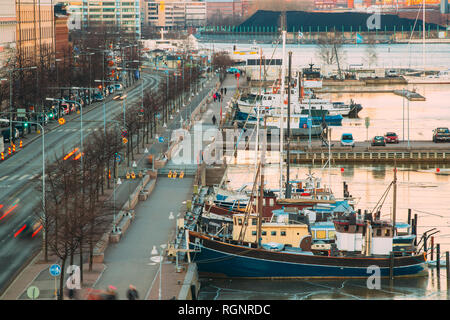 Helsinki, Finnland - 6 Dezember, 2016: Blick auf Pohjoisranta Street und Schiffe, Boote und Yachten vor Anker in der Nähe von Pier am Abend Zeit. Stockfoto