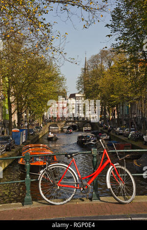 Rot oben sitzen und Fahrrad über Kanal, Amsterdam, Niederlande, betteln, Europa Stockfoto