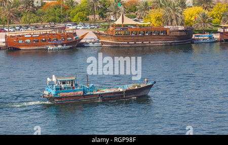 Einem traditionellen hölzernen Dhow Motoren Dubai Creek in Dubai, VAE. Restaurant daus gesehen werden kann im Hintergrund. Stockfoto