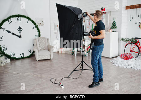Fotograf passt das Blitzlicht auf Studio. Stockfoto