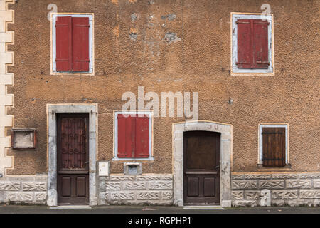 Altes Haus mit roten Fenstern und braune Türen in Pyrenäen Stockfoto