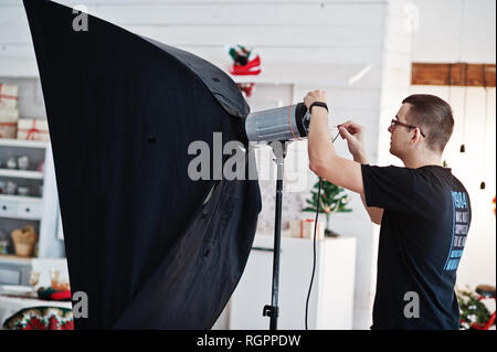 Fotograf passt das Blitzlicht auf Studio. Stockfoto