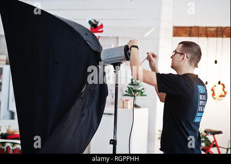 Fotograf passt das Blitzlicht auf Studio. Stockfoto