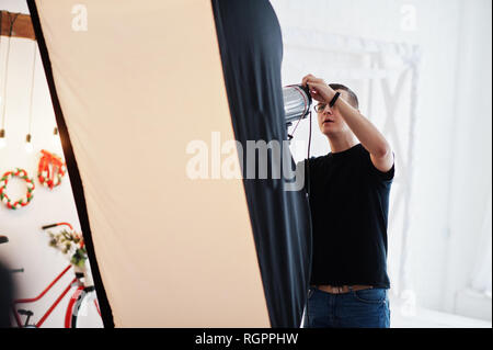 Fotograf passt das Blitzlicht auf Studio. Stockfoto