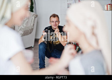 Mann Fotograf Shooting im Studio zwei Mädchen, während sie ihre eigenen Masken Creme machen. Professioneller Fotograf auf der Arbeit. Stockfoto