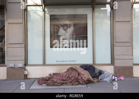 Obdachlosen schläft am Broadway vor Victoria's Secret Store Fenster in der trendigen Upper West Side von Manhattan, New York City. Stockfoto