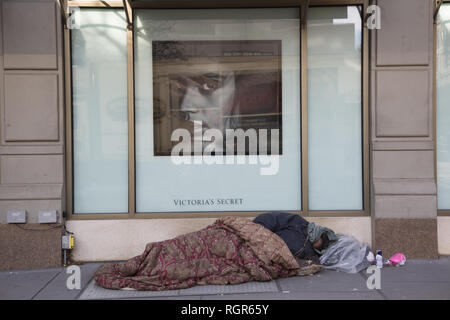 Obdachlosen schläft am Broadway vor Victoria's Secret Store Fenster in der trendigen Upper West Side von Manhattan, New York City. Stockfoto