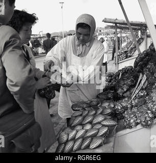 1950er Jahre, historische, Japan, Fisch, Stall, weiblichen Markt standbesitzer Kunden. Stockfoto