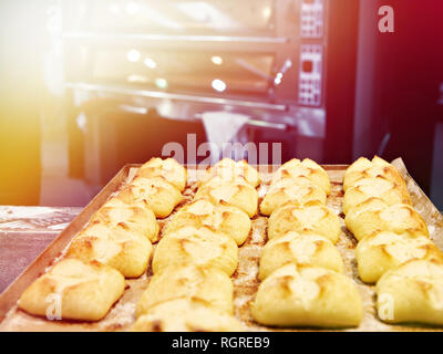 Frisch gebackene Brötchen auf ein Backblech und Backofen Stockfoto