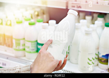 Frau entscheidet, Milch und Milchprodukte im Supermarkt Stockfoto