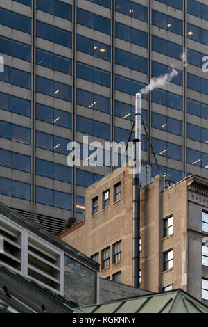 Dampfende Schornstein in der Nähe von Post Office Square an der Oberseite des 24 Bundes Straße Gebäude. Schuß auf einfrieren Tag in Boston, der sich hinter einem Federal Building ist. Stockfoto