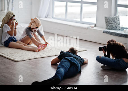 Das Team von zwei Fotografen schießen auf Studio Zwillinge Mädchen, während sie ihre eigenen Masken Creme machen. Professioneller Fotograf auf der Arbeit. Stockfoto