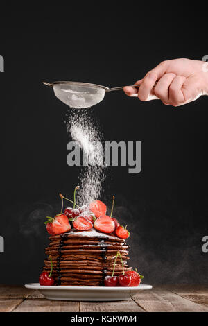 Abstauben Puderzucker auf Dessert Stockfoto