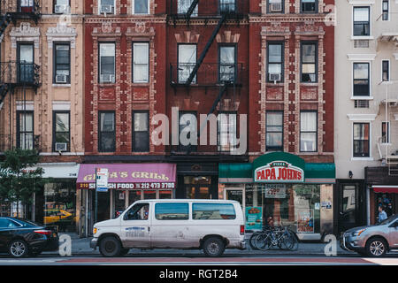 New York, USA - Juni 01, 2018: die Fassaden der typischen Mehrfamilienhaus mit Feuer entkommt in Manhattan, New York, Restaurants im Erdgeschoss. Mieten Stockfoto
