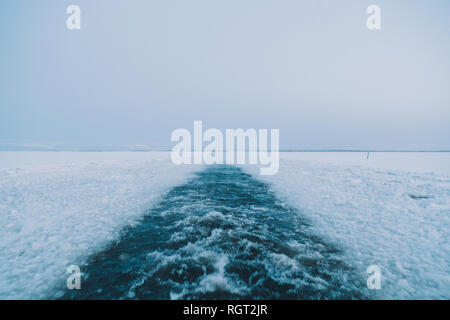 Kaltes Wasser des Arktischen Meer plantschen in der Nähe von Stücke gebrochene Eis auf grauen Tag Stockfoto