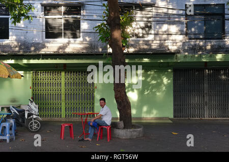 Ein einsamer Mann sitzt in einem Open-air-Essen in Chinatown, Bangkok, Thailand ausgeht, warten bedient zu werden. Stockfoto