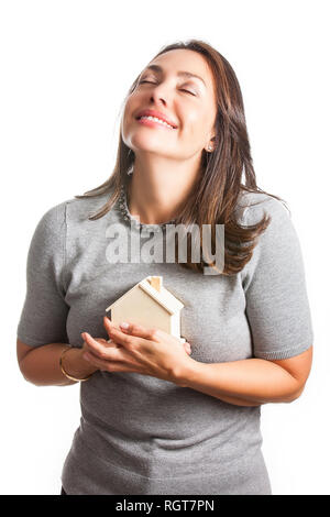 Junge schöne Frau träumt mit einem neuen Haus auf weißem Hintergrund Stockfoto