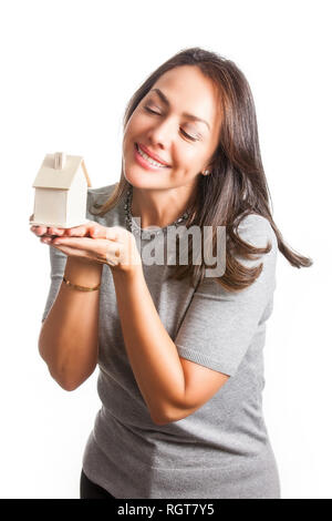 Junge schöne Frau träumt mit einem neuen Haus auf weißem Hintergrund Stockfoto