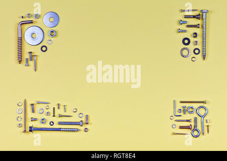 Gelbe abstrakt Hintergrund mit Schrauben und Unterlegscheiben in den Ecken. Stockfoto