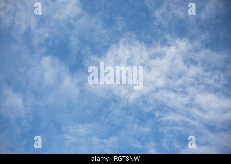 Hell Blau sonnigen Himmel mit flauschigen weissen Wolken schwebend auf einem hellen, sonnigen Tag in England, Großbritannien Stockfoto