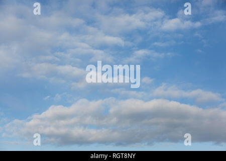 Hell Blau sonnigen Himmel mit flauschigen weissen Wolken schwebend auf einem hellen, sonnigen Tag in England, Großbritannien Stockfoto