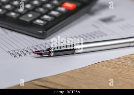 Taschenrechner und Kugelschreiber liegen auf finanzielle Dokument Stockfoto