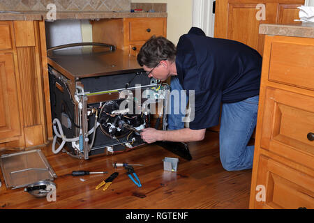 Appliance Reparatur Techniker arbeitet auf gebrochen Geschirrspüler Stockfoto