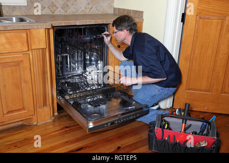 Appliance Reparatur Techniker arbeitet auf gebrochen Geschirrspüler Stockfoto