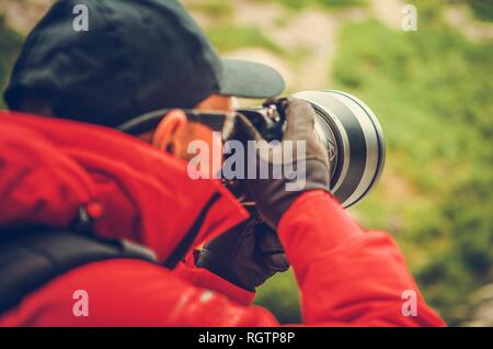 Tele Natur Fotografie. Kaukasische professionelle Fotografen mit großen Super Teleobjektiv an Digitalkamera. Stockfoto