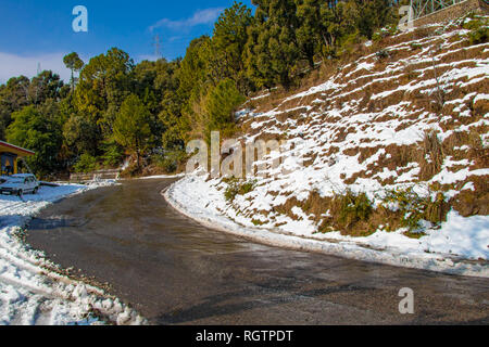 Landschaftlich reizvolle Straße durch das Tal von banikhet Dalhousie Himachal Pradesh mit Schnee Berge und Bäume abgedeckt. Bergauf scenic road winter Reisen c Stockfoto