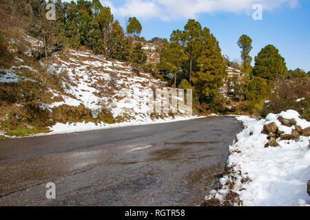 Landschaftlich reizvolle Straße durch das Tal von banikhet Dalhousie Himachal Pradesh mit Schnee Berge und Bäume abgedeckt. Bergauf scenic road winter Reisen c Stockfoto