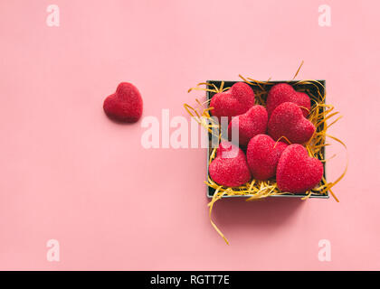 Candy Herz Flach Foto eine kleine Schachtel mit Zucker Bonbons in Form von Herzen steht auf einem rosa Hintergrund Stockfoto