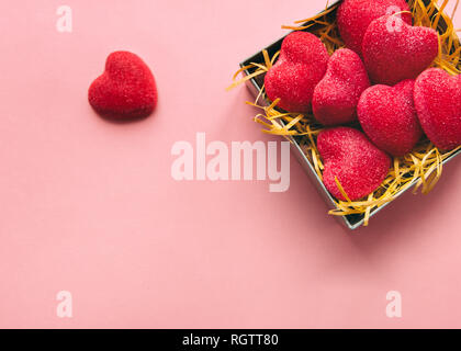 Candy Herz Ansicht von Oben eine kleine Schachtel mit Zucker Bonbons in Form von Herzen steht auf einem rosa Hintergrund Nahaufnahme Stockfoto