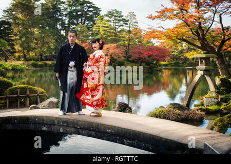 KANAZAWA, Japan - 15. NOVEMBER 2018: Hochzeit paar im traditionellen Kimono für pre Posing - Hochzeit Fotosession auf einer Brücke in Kenrokuen Garten während m Stockfoto