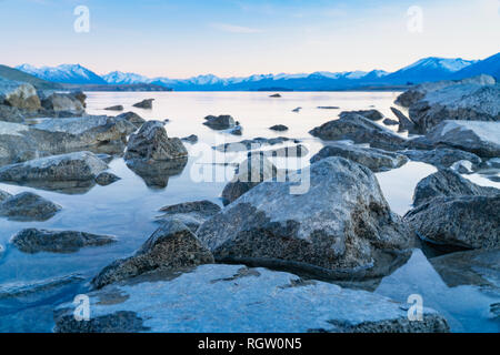 Lake Tekapo sunsise über felsige Küste und niedrigem Wasserstand der Ruhe ruhige See Stockfoto