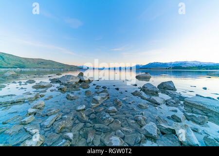 Lake Tekapo sunsise über felsige Küste und niedrigem Wasserstand der Ruhe ruhige See Stockfoto