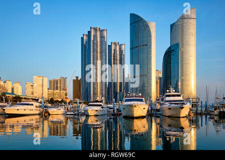 Busan Hafen mit Yachten, Marina City Wolkenkratzer mit Reflexion auf Sonnenuntergang, Südkorea Stockfoto