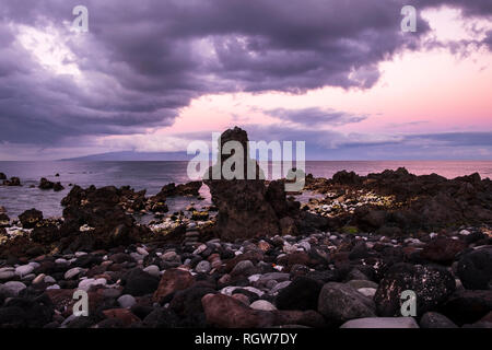 Blick nach Westen in Richtung der Insel La Gomera von einem Kieselstrand in Playa San Juan im Morgengrauen an einem bewölkten Tag, Teneriffa, Kanarische Inseln, Spanien Stockfoto