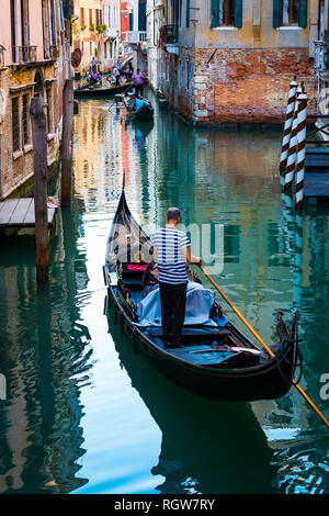 Italien, Venedig - 5 September, 2018: Männer gondolieri Gondeln fahren mit Touristen in Venedig in Italien. Stockfoto