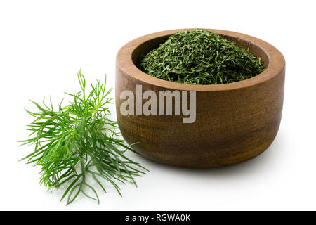 Getrocknete gehacktem Dill in einem dunklen Holz Schüssel neben frischen Dill Blätter isoliert auf Weiss. Stockfoto