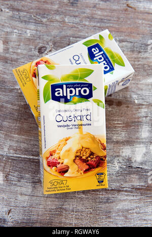 Zwei Kartons von Alpro. vegan, ohne Milchprodukte Vanillepudding auf distressed Holz- Fach. Stockfoto