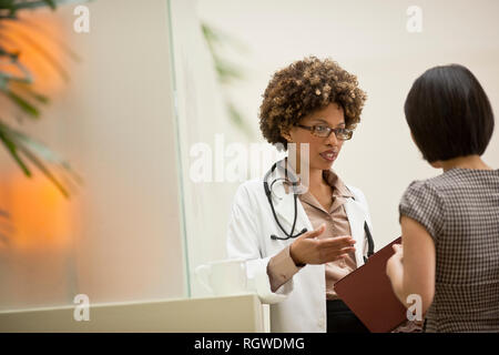 Ärztin im Gespräch mit Patienten. Stockfoto